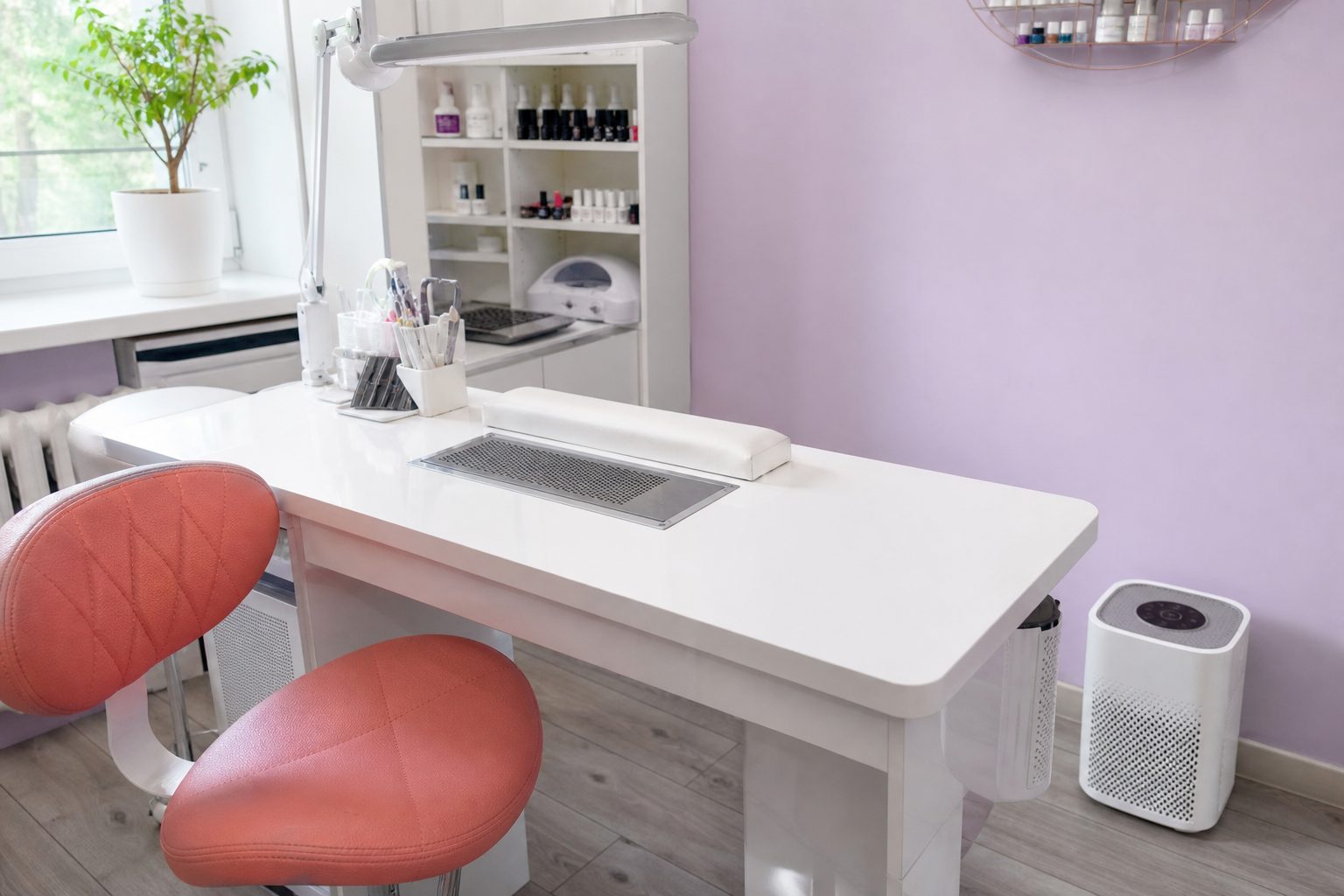 Nail station with a ventilated downdraft table and compact air purifier in a bright studio